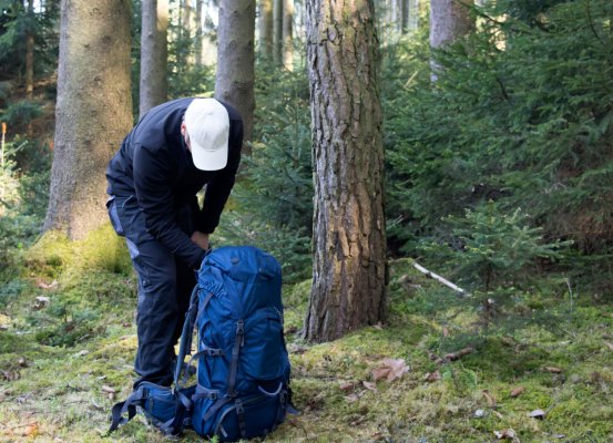 man with backpack forest wood backpacking tents